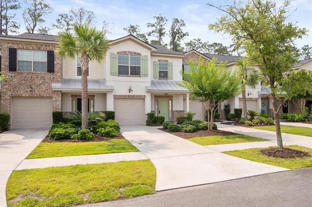404 Mariners Cir, Saint Simons Island, GA 31522 - townhome / multi-family property featuring stucco siding, driveway, a garage, brick siding, and metal roof