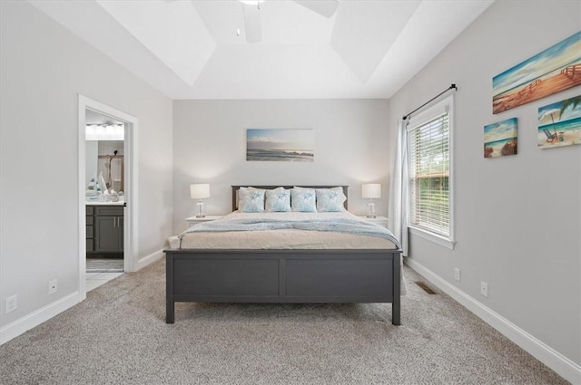 404 Mariners Cir, Saint Simons Island, GA 31522 - carpeted bedroom with a raised ceiling, connected bathroom, and ceiling fan