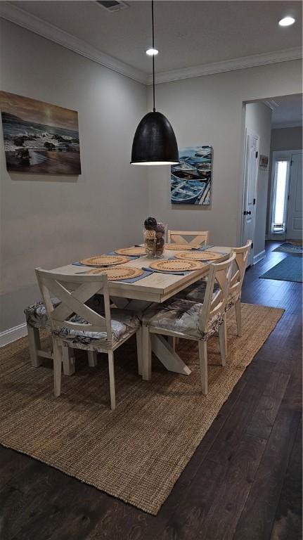 dining area featuring dark hardwood / wood-style flooring and crown molding