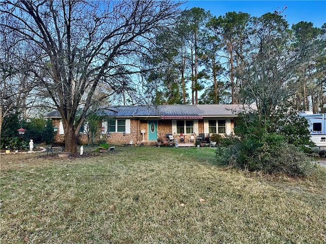 ranch-style home featuring a front yard, covered porch, and brick siding