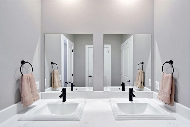 full bathroom with double vanity and a sink