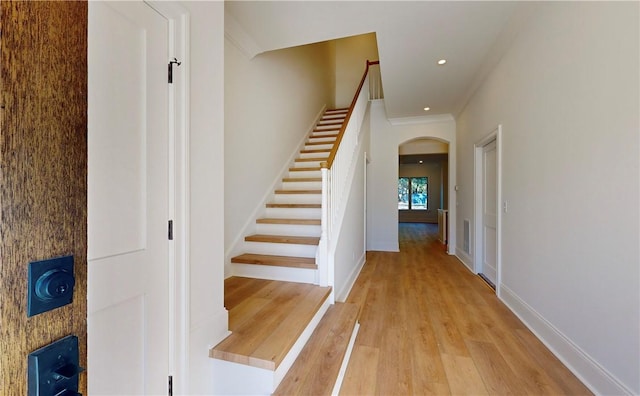 187 Fifty Oaks Ln, Saint Simons Island, GA 31522 - staircase with arched walkways, wood finished floors, ornamental molding, baseboards, and recessed lighting