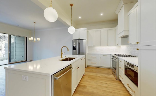 187 Fifty Oaks Ln, Saint Simons Island, GA 31522 - kitchen featuring stainless steel appliances, a sink, tasteful backsplash, light wood-type flooring, and a chandelier