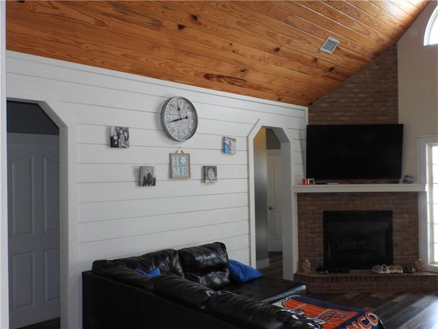 living room featuring wood ceiling, vaulted ceiling, wooden walls, wood-type flooring, and a fireplace