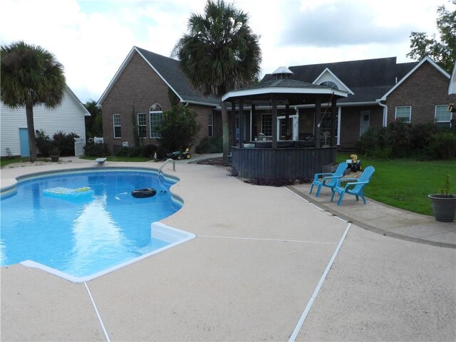 view of swimming pool with a gazebo, a diving board, a lawn, and a patio