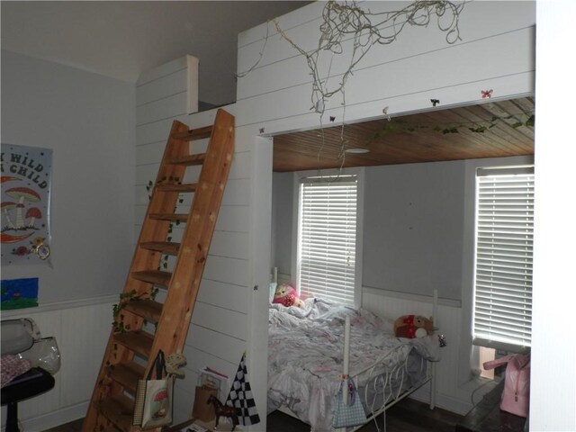 bedroom featuring hardwood / wood-style floors, wooden walls, and wooden ceiling