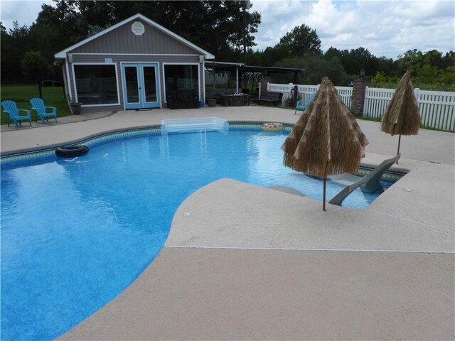 view of pool featuring a patio area and an outbuilding