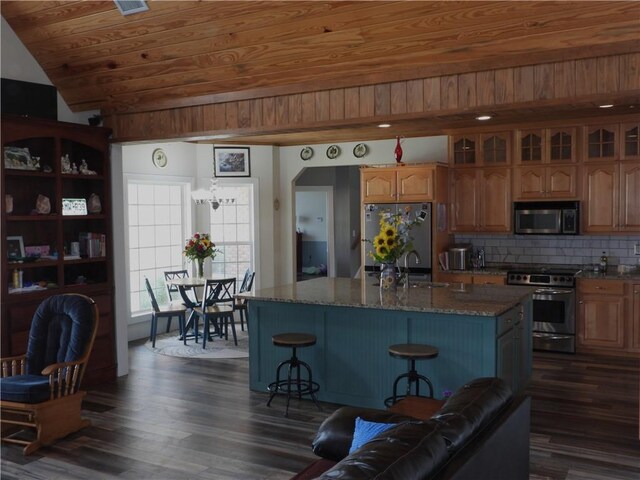 kitchen featuring appliances with stainless steel finishes, dark hardwood / wood-style flooring, wood ceiling, sink, and a center island with sink