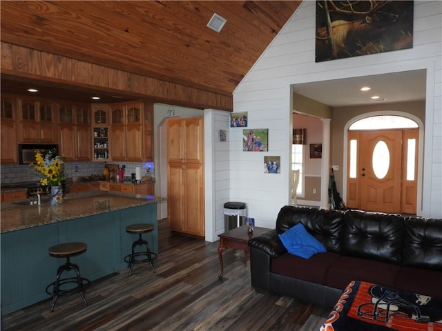 living room featuring wooden walls, dark hardwood / wood-style flooring, wood ceiling, and vaulted ceiling