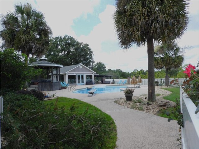 view of swimming pool featuring a bar, a patio, and a hot tub