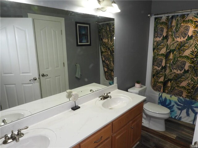 full bathroom with hardwood / wood-style floors, vanity, toilet, and shower / bath combination with curtain