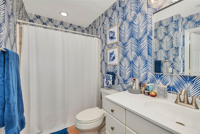 bathroom featuring vanity, a textured ceiling, and toilet