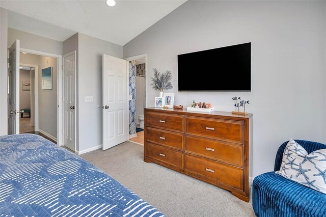 bedroom featuring light colored carpet and vaulted ceiling