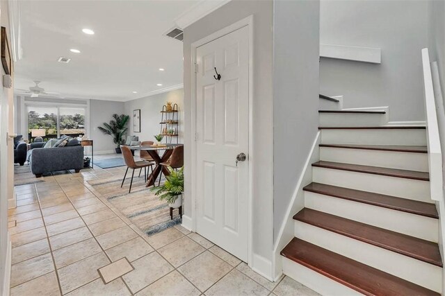 stairs featuring ceiling fan, tile patterned flooring, and ornamental molding