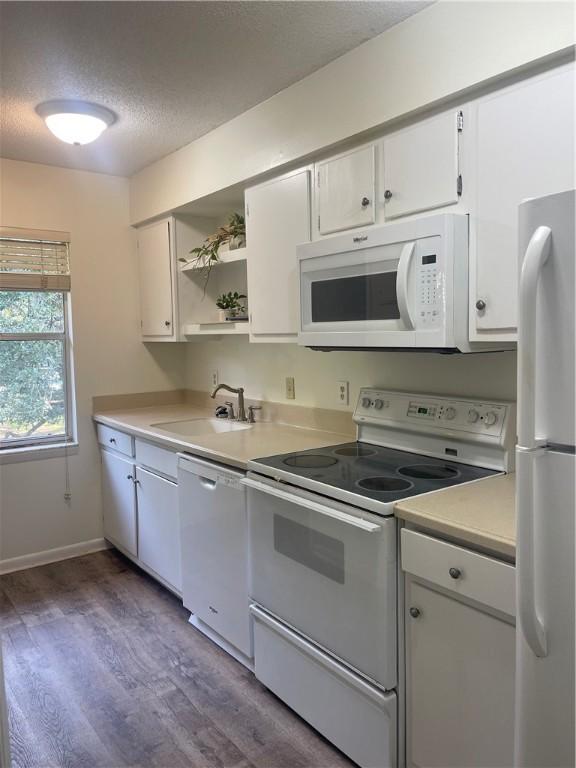 800 Mallery St Unit C-30, Saint Simons Island, GA 31522 - kitchen featuring white appliances, light countertops, a textured ceiling, open shelves, and dark wood finished floors