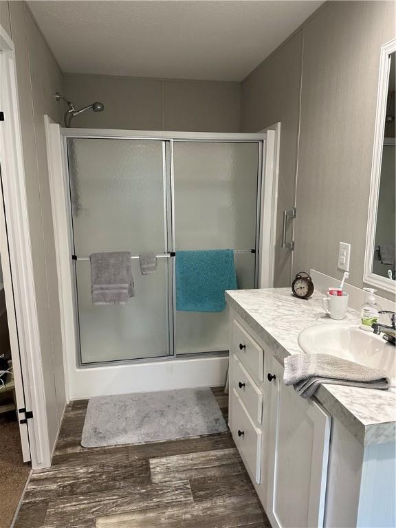 bathroom with vanity, hardwood / wood-style floors, and an enclosed shower