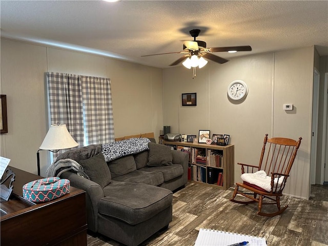 living room featuring a textured ceiling, hardwood / wood-style flooring, and ceiling fan