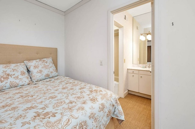 bedroom featuring light carpet, ensuite bath, and crown molding