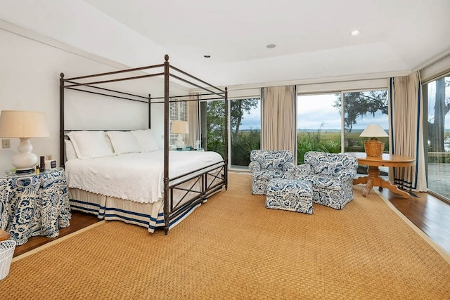 bedroom with multiple windows, access to outside, and wood-type flooring