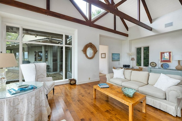 living room featuring hardwood / wood-style floors, plenty of natural light, high vaulted ceiling, and beamed ceiling