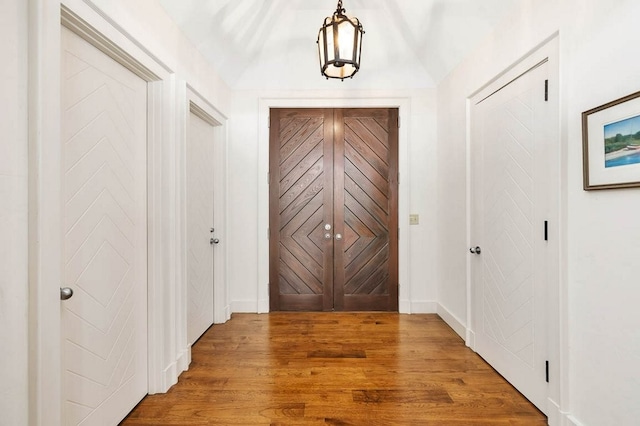 hallway featuring vaulted ceiling and hardwood / wood-style floors