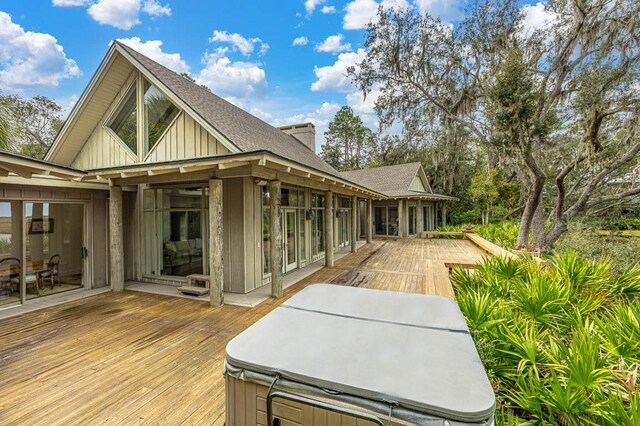 exterior space featuring a wooden deck and a hot tub