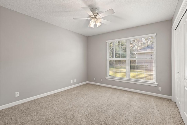 spare room featuring carpet flooring, a textured ceiling, and ceiling fan