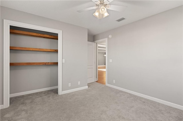 unfurnished bedroom featuring ceiling fan, a closet, and light carpet