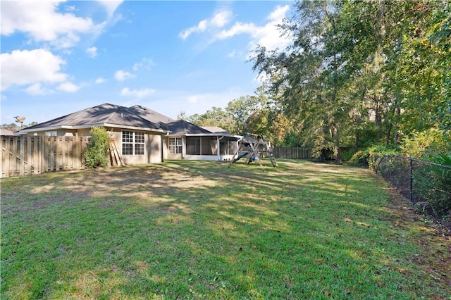 view of yard featuring a sunroom and a playground