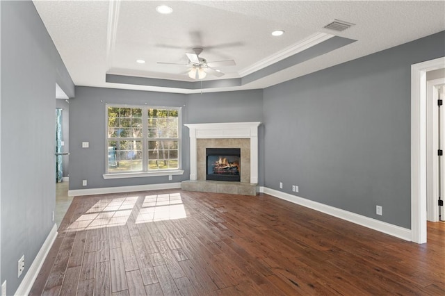 unfurnished living room with a raised ceiling, ceiling fan, and wood-type flooring