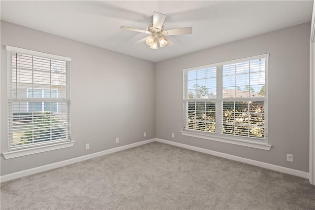 carpeted spare room featuring ceiling fan