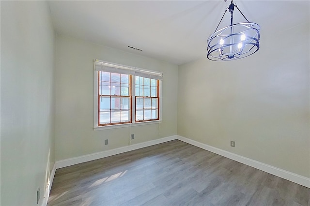 1206 Morningside Dr, Waycross, GA 31501 - spare room with a chandelier and wood finished floors