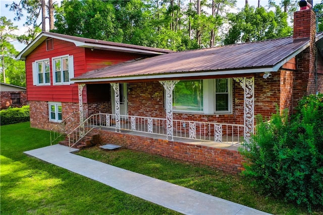 1206 Morningside Dr, Waycross, GA 31501 - tri-level home with a porch, a front lawn, a chimney, a metal roof, and brick siding