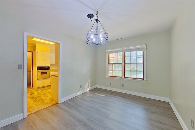 1206 Morningside Dr, Waycross, GA 31501 - unfurnished room with light wood-type flooring and a chandelier