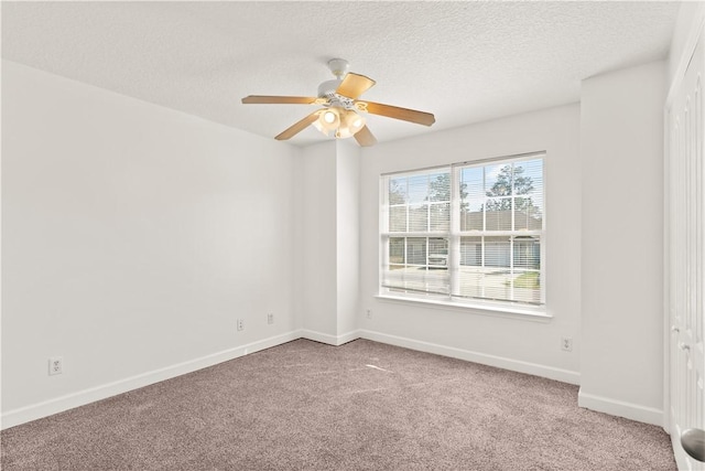 empty room with baseboards, carpet, ceiling fan, and a textured ceiling