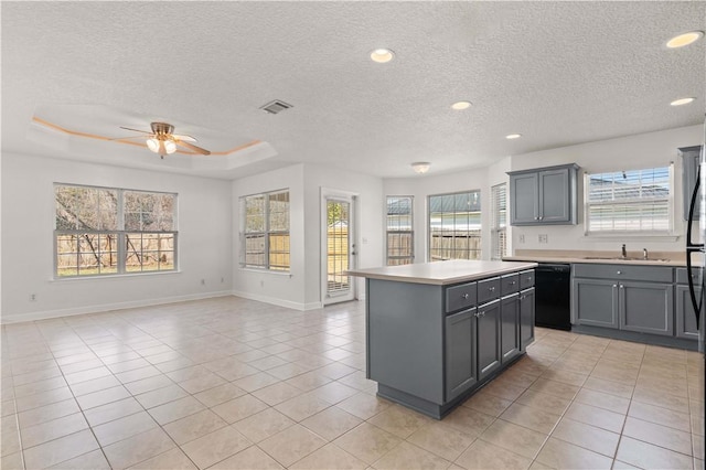 kitchen featuring visible vents, gray cabinetry, light countertops, black dishwasher, and a sink