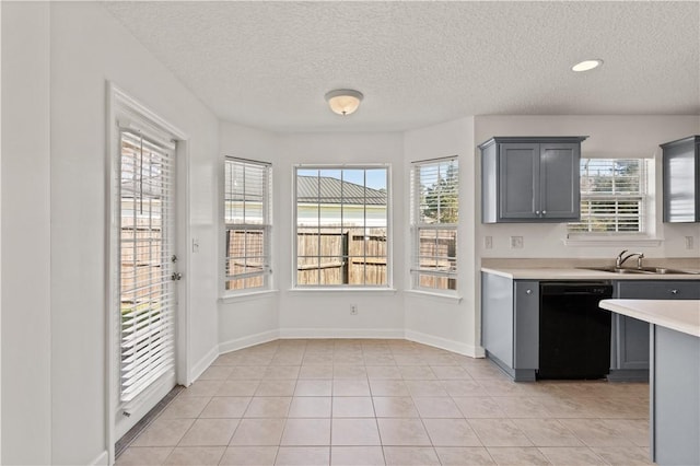 kitchen featuring dishwasher, light countertops, a healthy amount of sunlight, and a sink