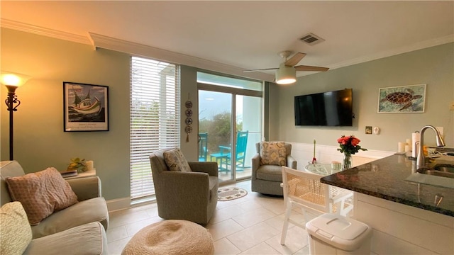 tiled living room featuring sink, ornamental molding, expansive windows, and ceiling fan