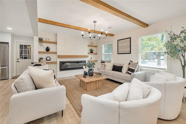 155 Mcdowell Ave, Brunswick, GA 31525 - living room featuring beamed ceiling, a chandelier, light wood finished floors, a glass covered fireplace, and recessed lighting