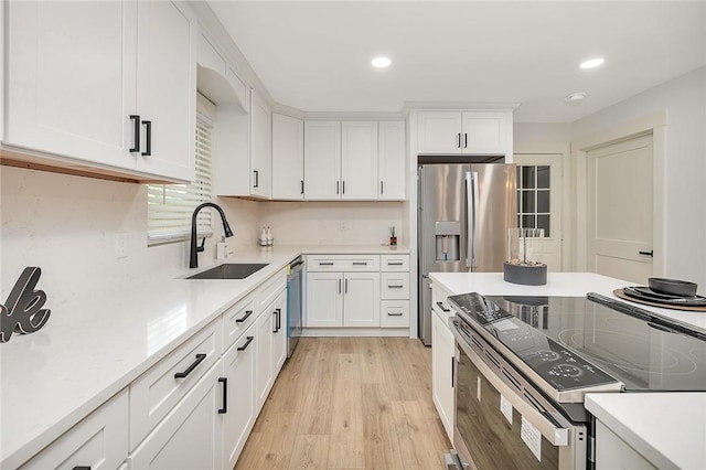 155 Mcdowell Ave, Brunswick, GA 31525 - kitchen with stainless steel appliances, a sink, white cabinets, light countertops, and recessed lighting