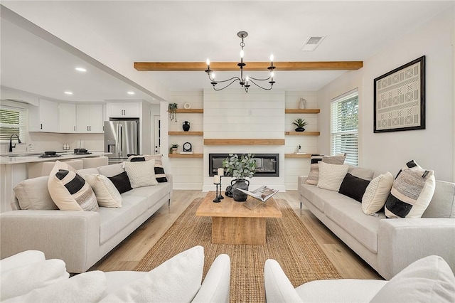 155 Mcdowell Ave, Brunswick, GA 31525 - living room with light wood-style floors, recessed lighting, a chandelier, beam ceiling, and a large fireplace