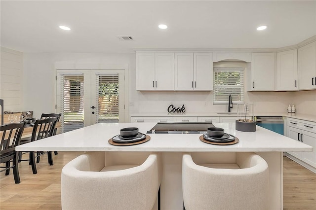 155 Mcdowell Ave, Brunswick, GA 31525 - kitchen featuring stainless steel dishwasher, french doors, a sink, white cabinets, and light countertops