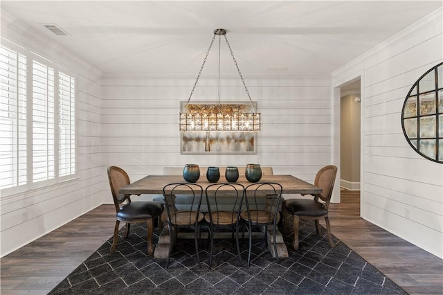 dining space featuring visible vents, wood finished floors, and ornamental molding