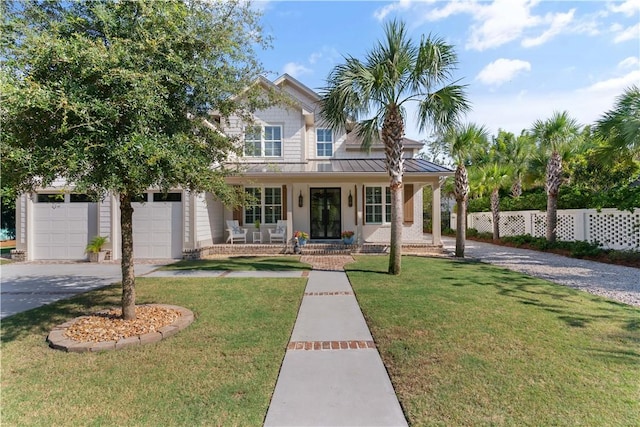view of front facade featuring a standing seam roof, fence, driveway, a front lawn, and a porch