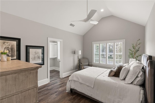 bedroom with visible vents, baseboards, dark wood-type flooring, vaulted ceiling, and a spacious closet