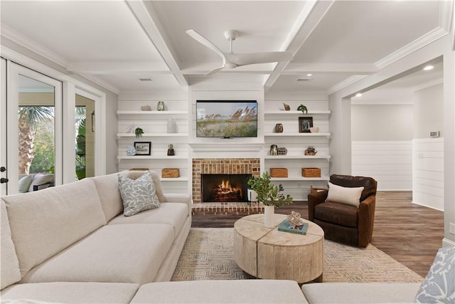 living room with coffered ceiling, beam ceiling, wood finished floors, built in features, and ornamental molding