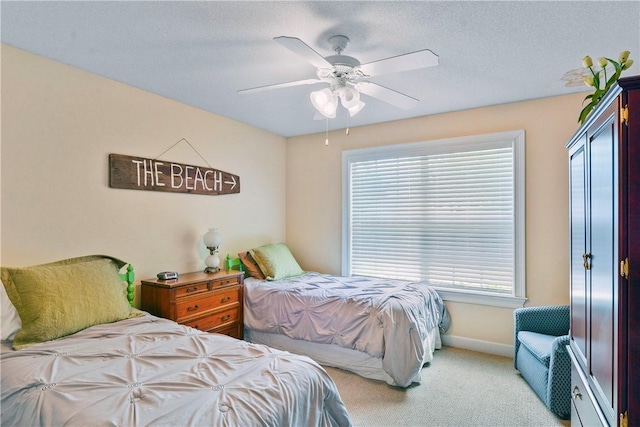 carpeted bedroom with baseboards, a ceiling fan, and a textured ceiling