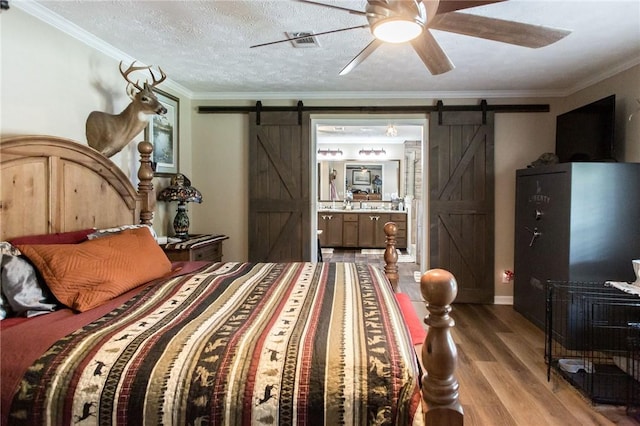 5618 Bowen Rd, Blackshear, GA 31516 - bedroom with a barn door, wood finished floors, crown molding, ensuite bath, and ceiling fan