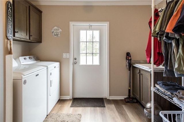 5618 Bowen Rd, Blackshear, GA 31516 - laundry room featuring cabinet space, washing machine and clothes dryer, light wood-type flooring, and ornamental molding