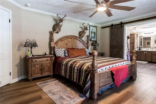 5618 Bowen Rd, Blackshear, GA 31516 - bedroom featuring a barn door, wood finished floors, ensuite bath, a ceiling fan, and crown molding